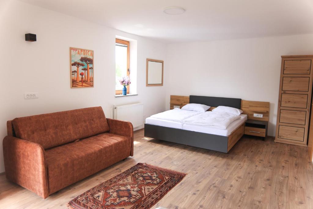 a living room with a bed and a couch at Apartments Katrca Bežigrad in Ljubljana