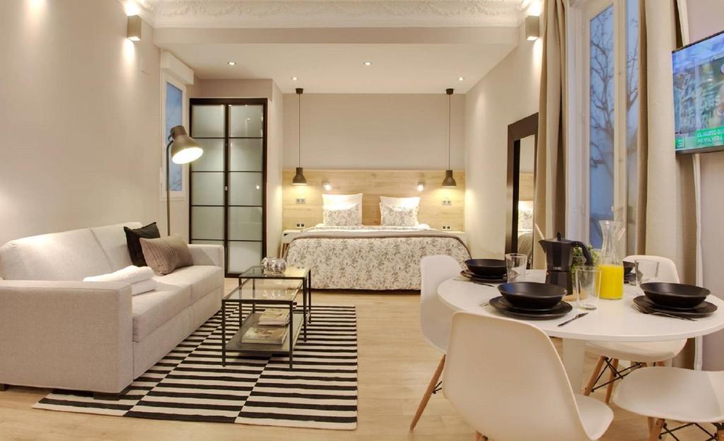 sala de estar con cama, mesa y sillas en Suites You Platinum, en Madrid