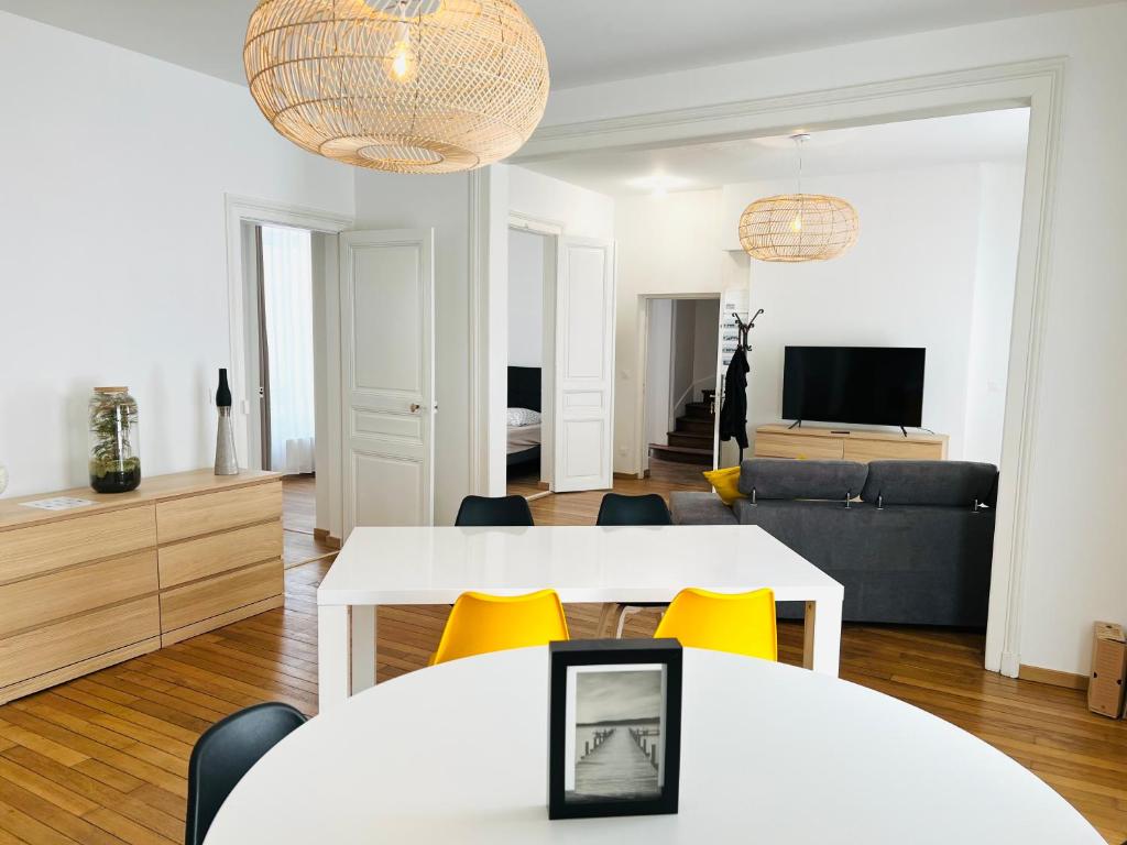 CHIC Appartement Type 4 / Parking Privé في رانس: غرفة معيشة مع طاولتين بيضاء وكراسي صفراء
