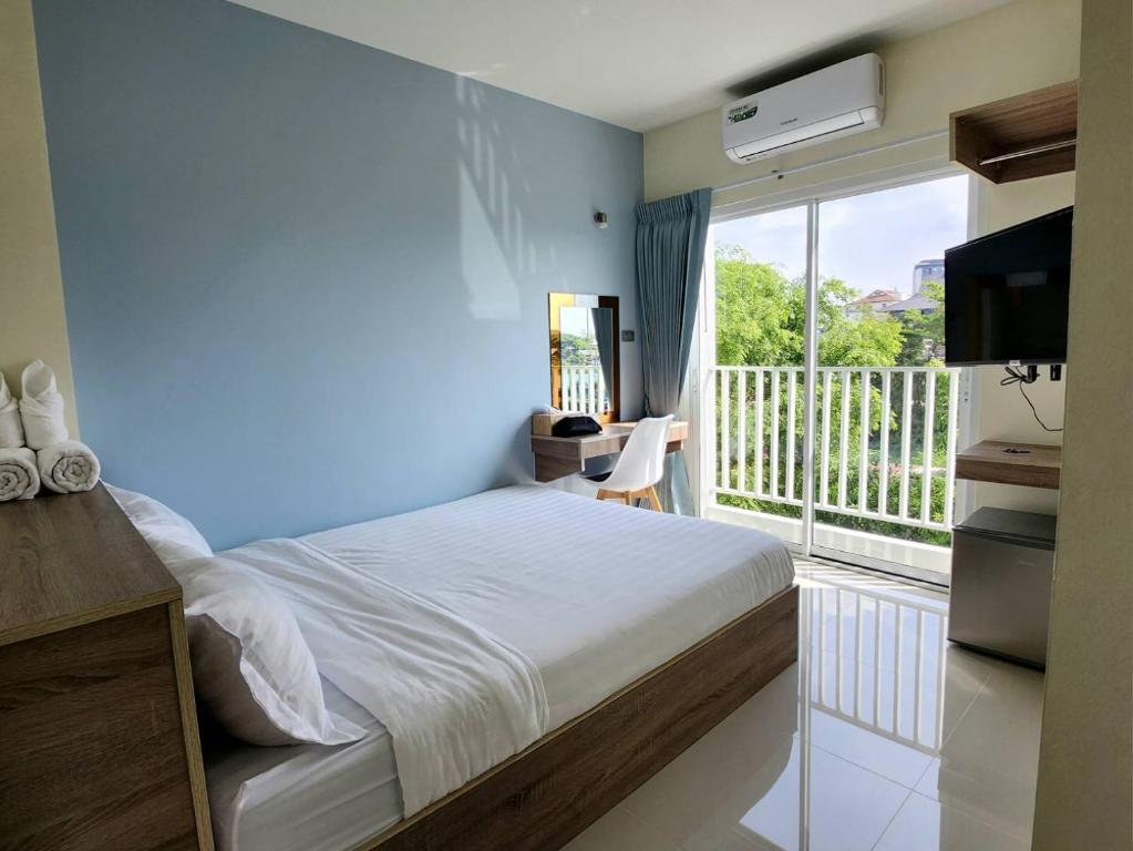 a bedroom with a bed and a balcony with a television at 98 Tower Chiang Mai in Chiang Mai