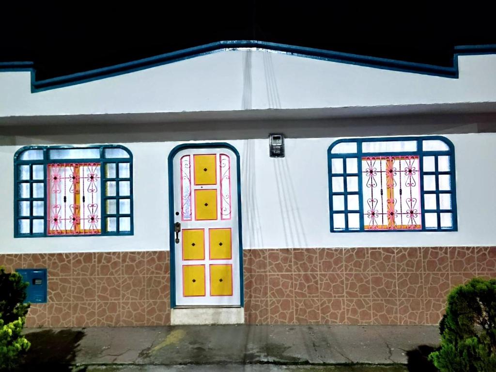 ein Haus mit zwei Fenstern und einer Tür in der Unterkunft Vivienda Turistica Cattleya in Filandia