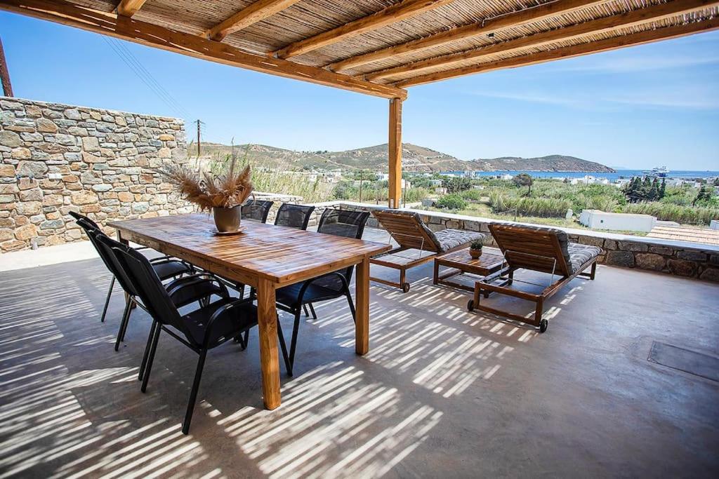 einen Holztisch und Stühle auf einer Terrasse in der Unterkunft SeaeyeVillas 2 in Livadion