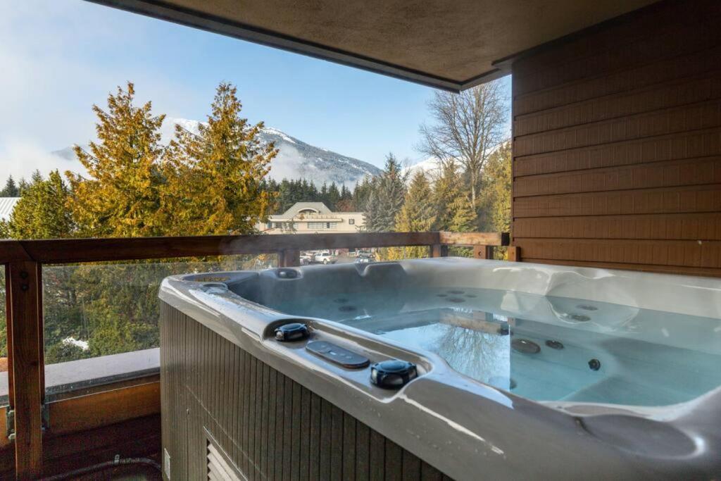 a jacuzzi tub on a balcony with a view at Patagonia 2 Bed 2 Bath with Private Hot Tub in Whistler