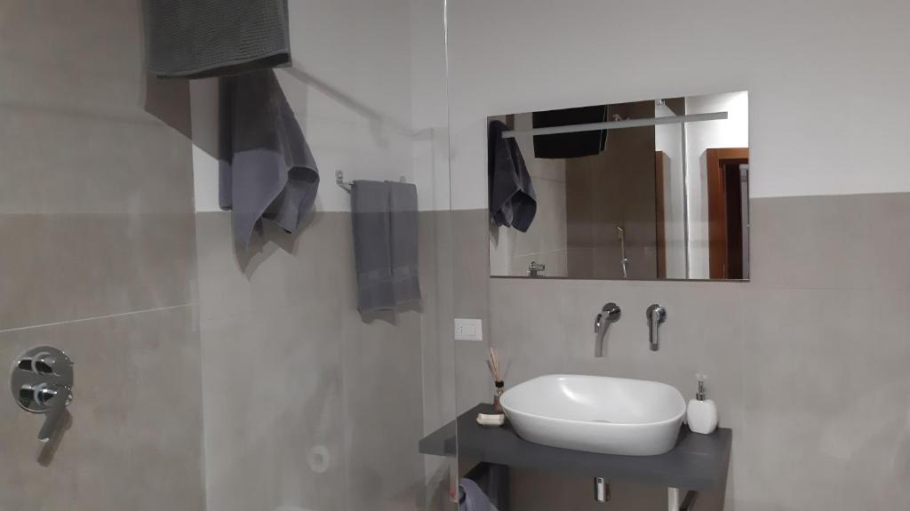 a white bathroom with a sink and a mirror at Civico in Gubbio