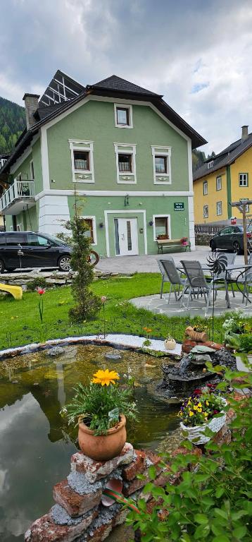 una casa con un estanque frente a un patio en Ferienwohnungen Trinker, en Ramingstein