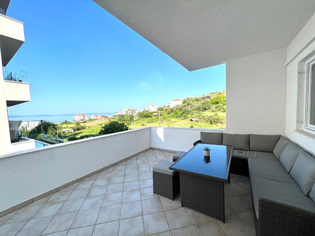Zimmer mit Sofa und Tisch auf dem Balkon in der Unterkunft Apartment Gabi in Split