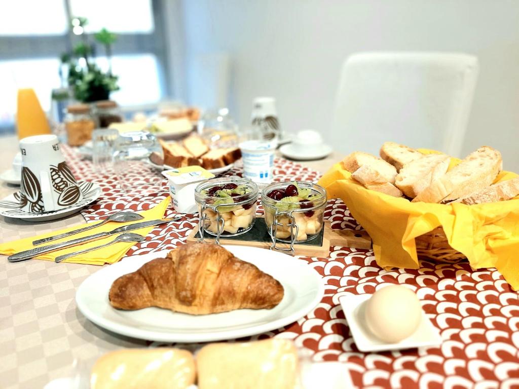 una mesa cubierta con un plato de pan y bollería en B&B La Jacaranda affittacamere, en SantʼAntìoco