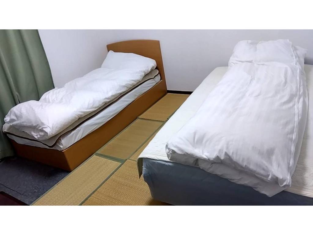 two beds sitting next to each other in a room at Kyoto - Hotel / Vacation STAY 36511 in Kyoto