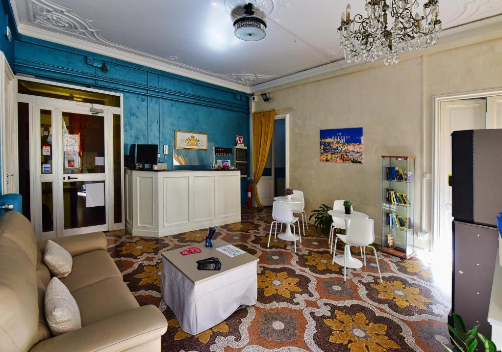 a living room with a couch and a table and chairs at Hotel Suisse in Genova