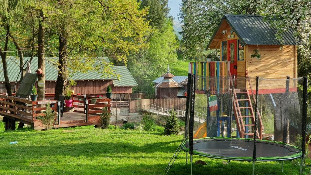um parque infantil com um escorrega e uma estrutura de jogos em Casuta dintre brazi - Valea Doftanei - 2 camere em Valea Doftanei