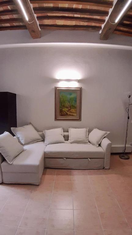 a living room with a couch and a painting on the wall at Civico in Gubbio