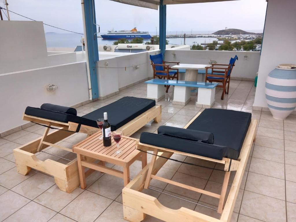 einen Balkon mit einem Tisch und Bänken sowie einem Tisch und Stühlen in der Unterkunft Katy's Home in Naxos Chora