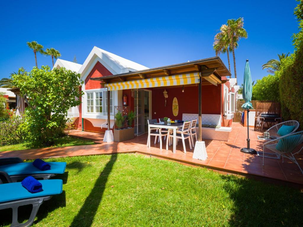 a patio with a table and chairs in a yard at Bungalow Tunos Maspalomas in San Bartolomé