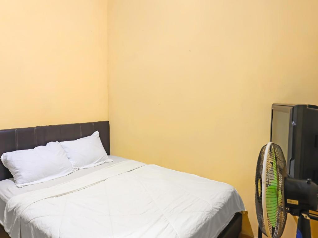 1 dormitorio con 1 cama y TV. en SPOT ON 92569 Anto Homestay Syariah en Nagoya