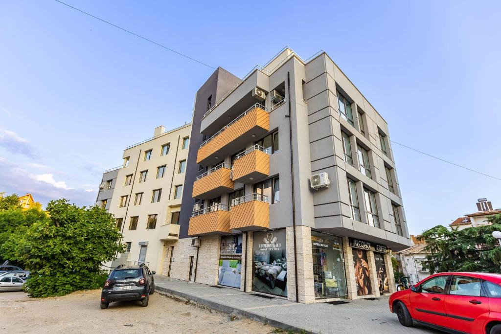 a building with a red car parked in front of it at апартаменти Пасажио in Sandanski