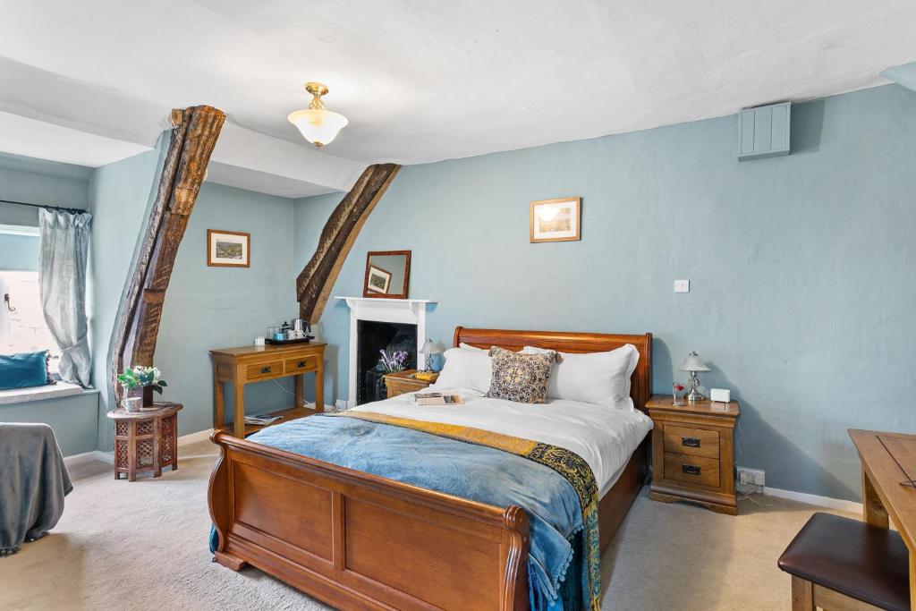 a bedroom with a large bed with blue walls at Bellamarsh Farm B&B in Newton Abbot