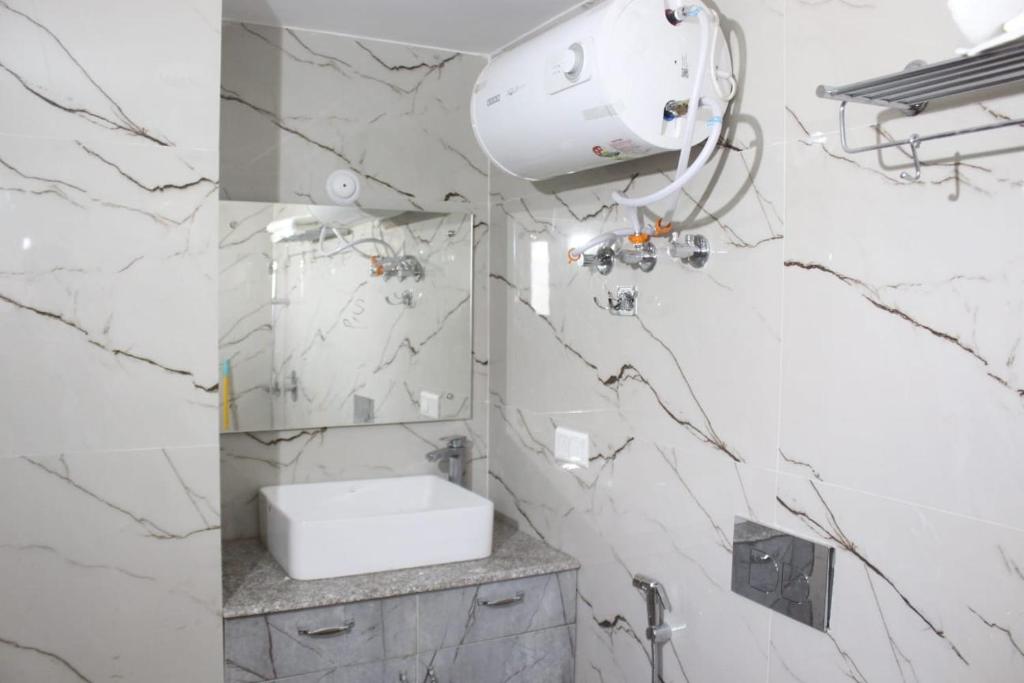W białej łazience znajduje się umywalka i lustro. w obiekcie Laspa Cottage, Bhimtal w mieście Bhimtal