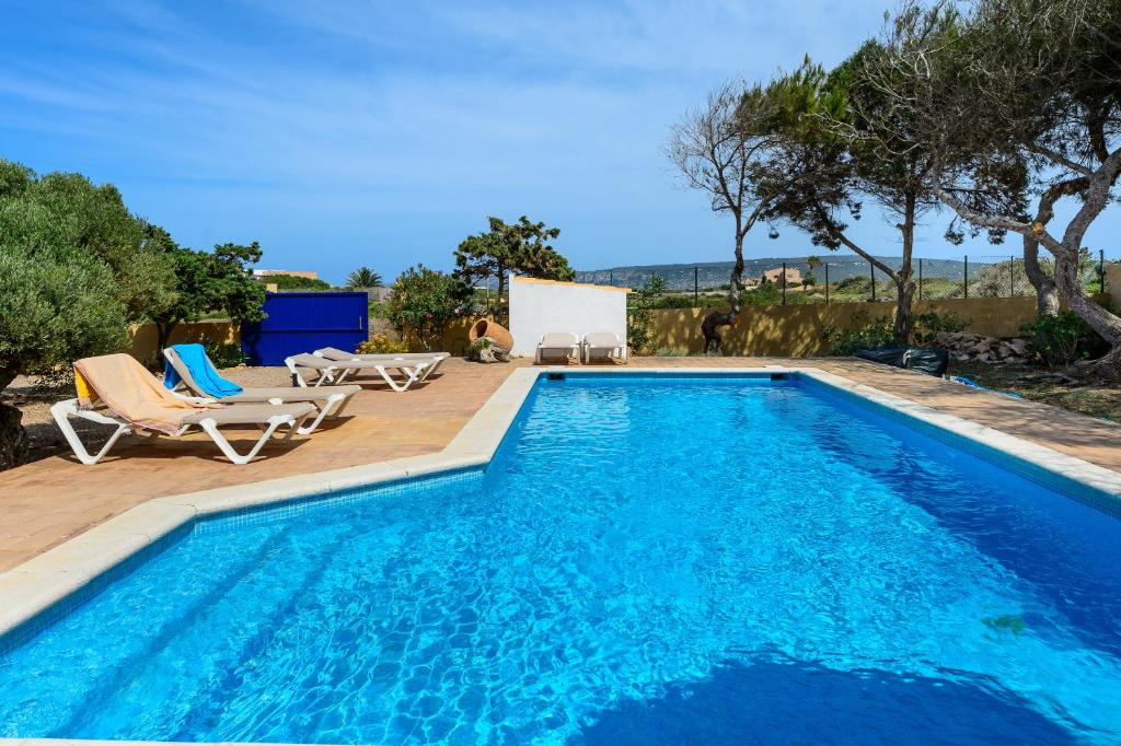 a swimming pool with two lounge chairs and a swimming pool at Ponent in Es Caló