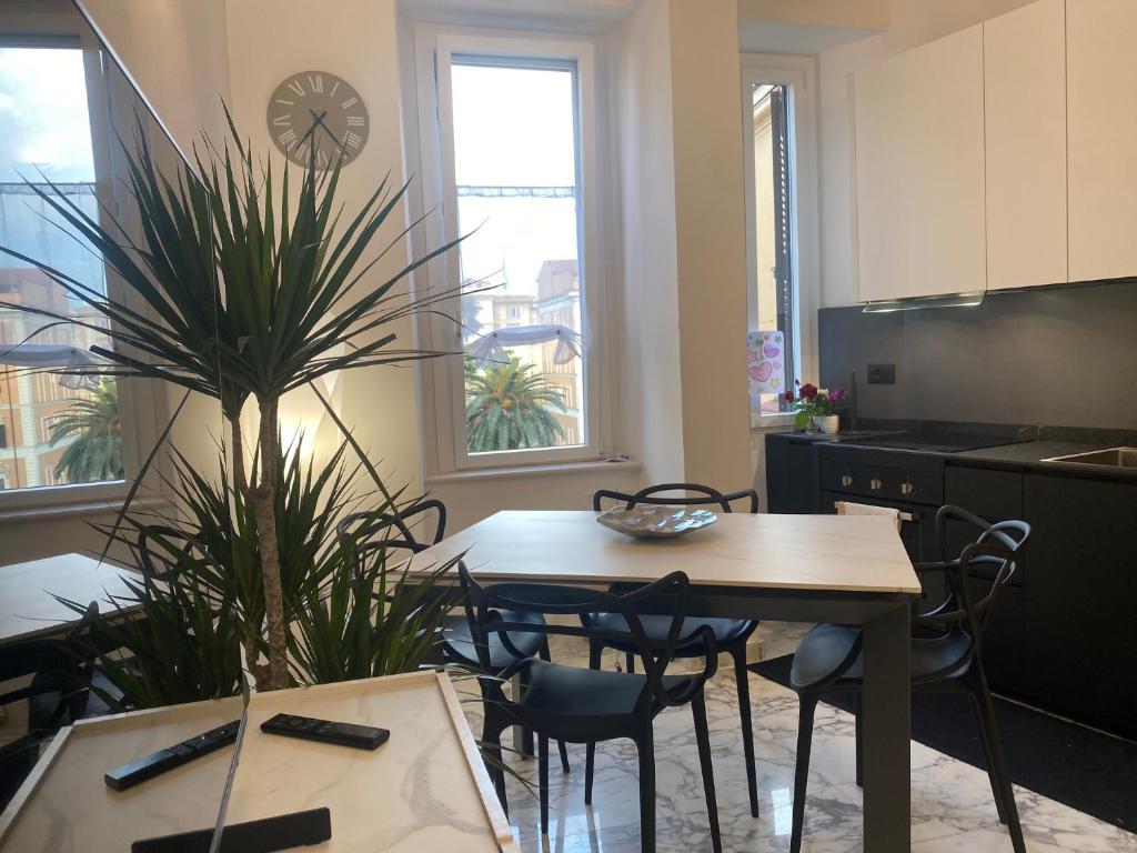 eine Küche mit einem Tisch, Stühlen und einer Pflanze in der Unterkunft Leonard Vatican House in Rom