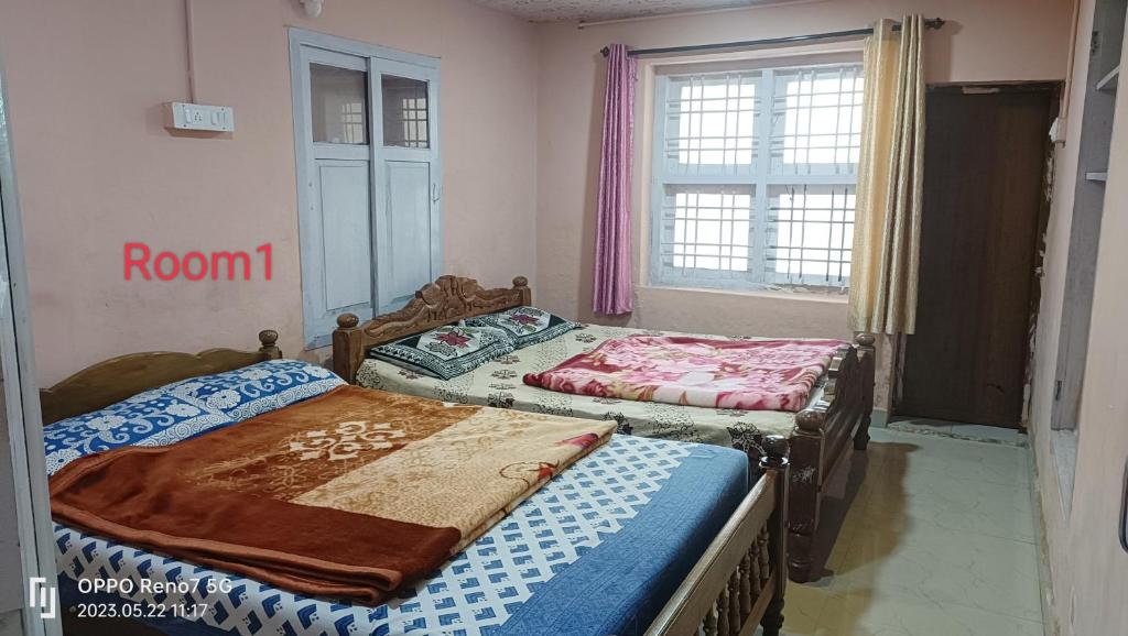 two twin beds in a room with a window at Sharon Home Stay in Madikeri