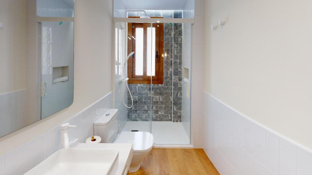 a white bathroom with a toilet and a sink at Apartamentos La Casa El Palo in El Rompido