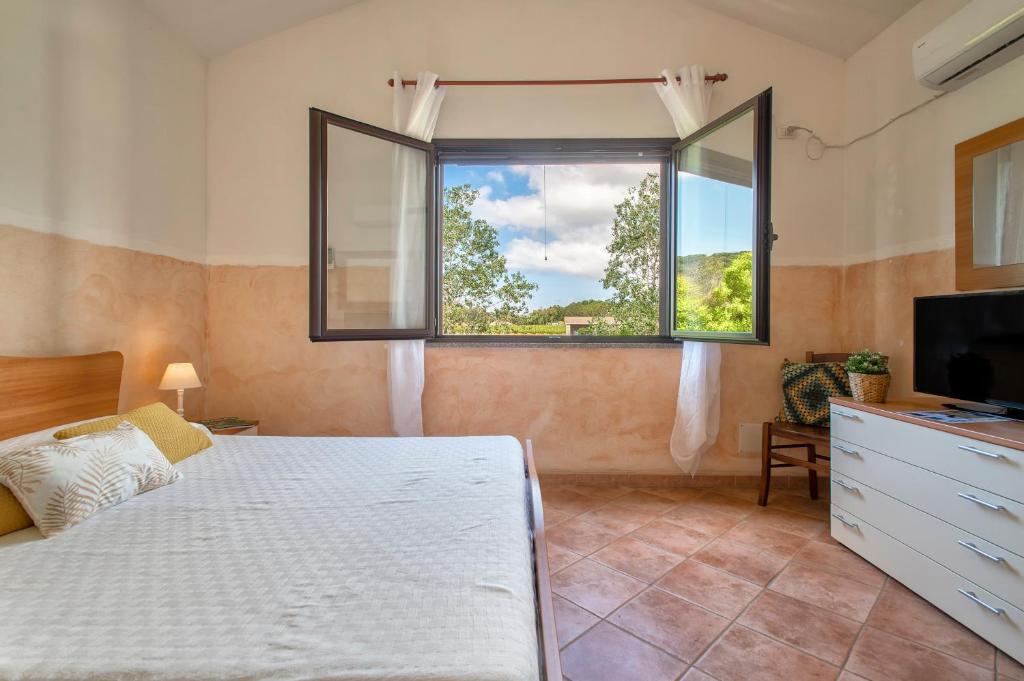 1 dormitorio con cama y ventana en Casa Vacanza Baratz 4, en Alghero