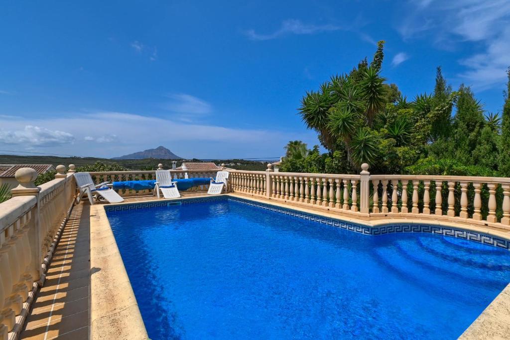 una piscina accanto a una recinzione con una piscina blu di Pinecrest a Jávea