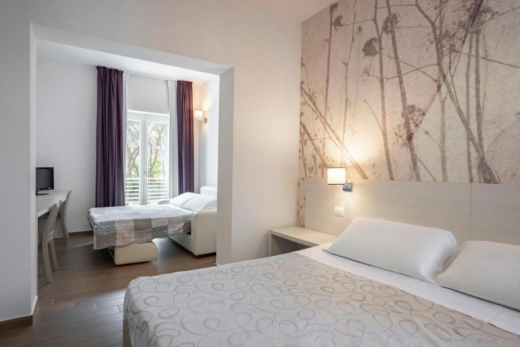 Postel nebo postele na pokoji v ubytování Hotel La Pineta