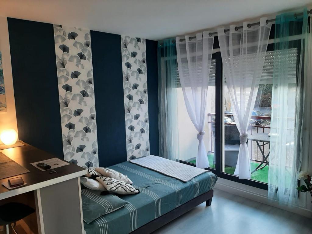 a bedroom with a bed in front of a window at Appartement T1 Hyper Centre avec Balcon in Bordeaux