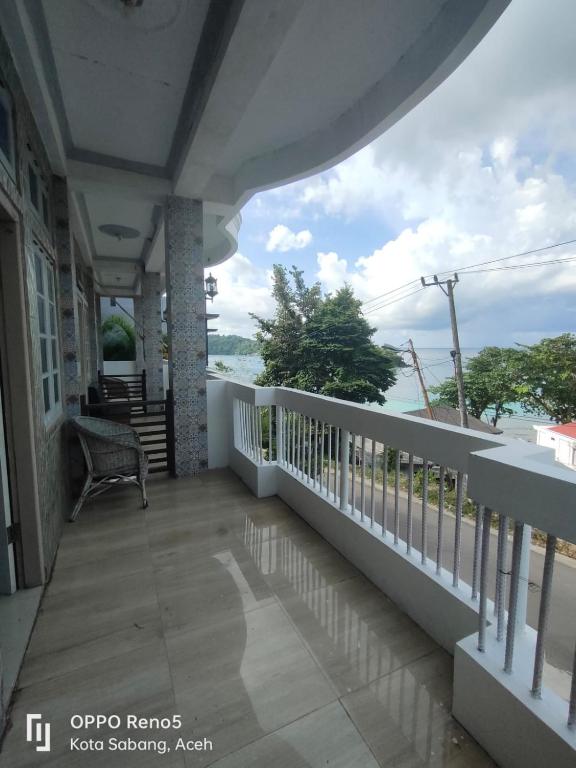 a balcony of a house with a view of the ocean at FURQAN GUEST HOUSE Family in Iboih