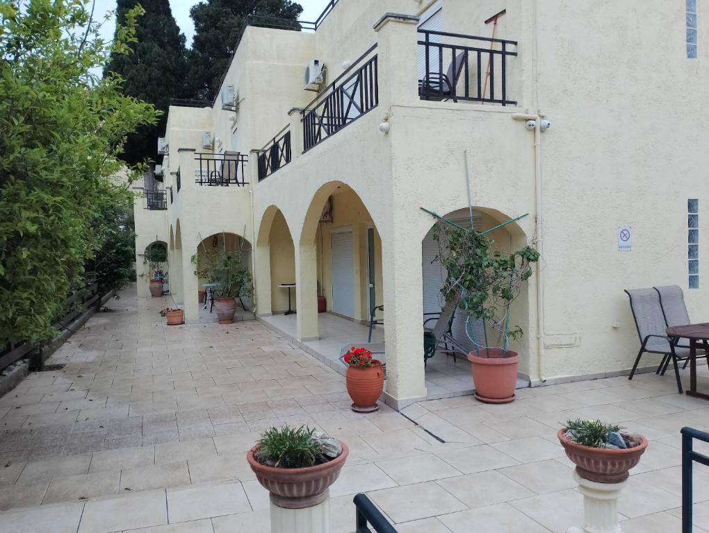 un cortile di un edificio con piante in vaso di Villa Mandarin Grove Alyanoe a Fodele