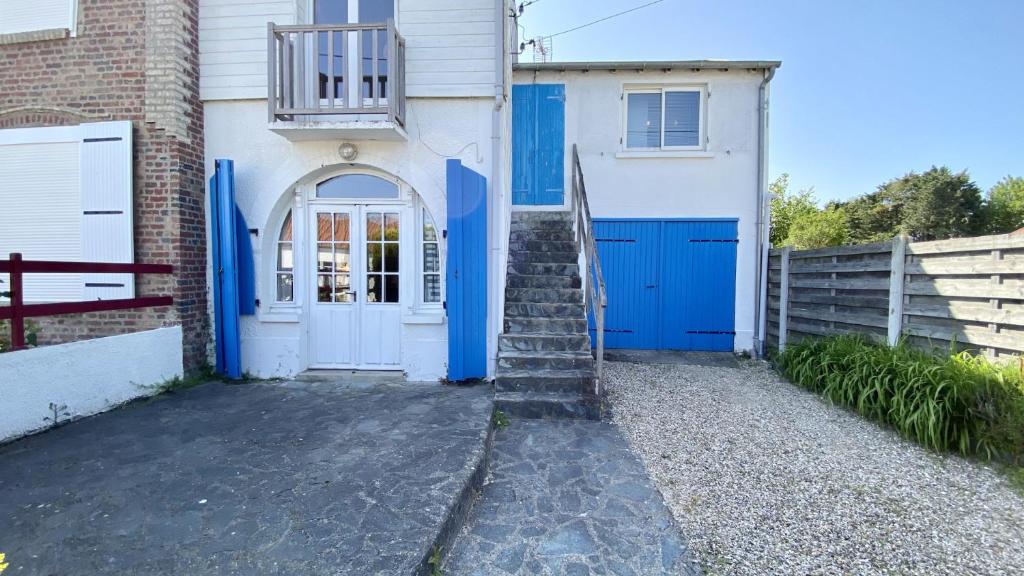 une maison blanche et bleue avec des portes bleues dans l'établissement La Graveline, au Crotoy
