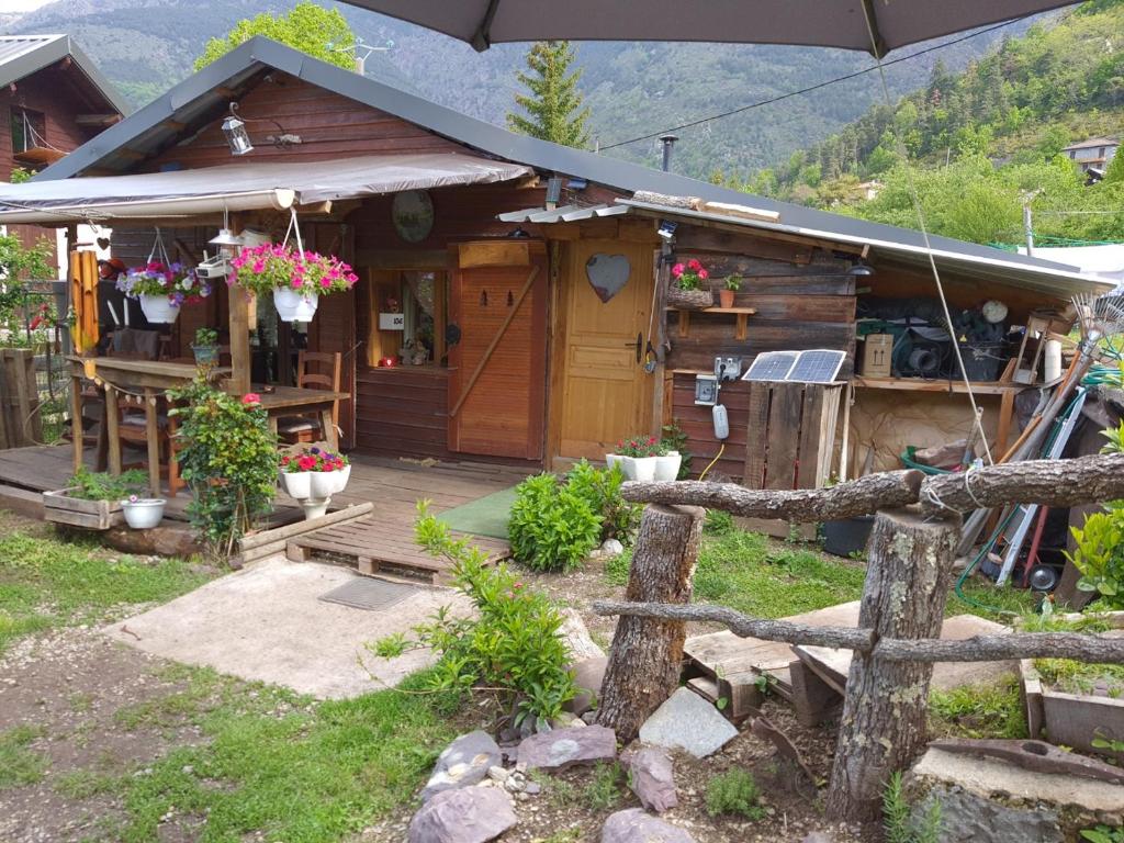 een houten huis met een hek ervoor bij LA CABANE, petite chambre agréable dans maison en bois in Valdeblore