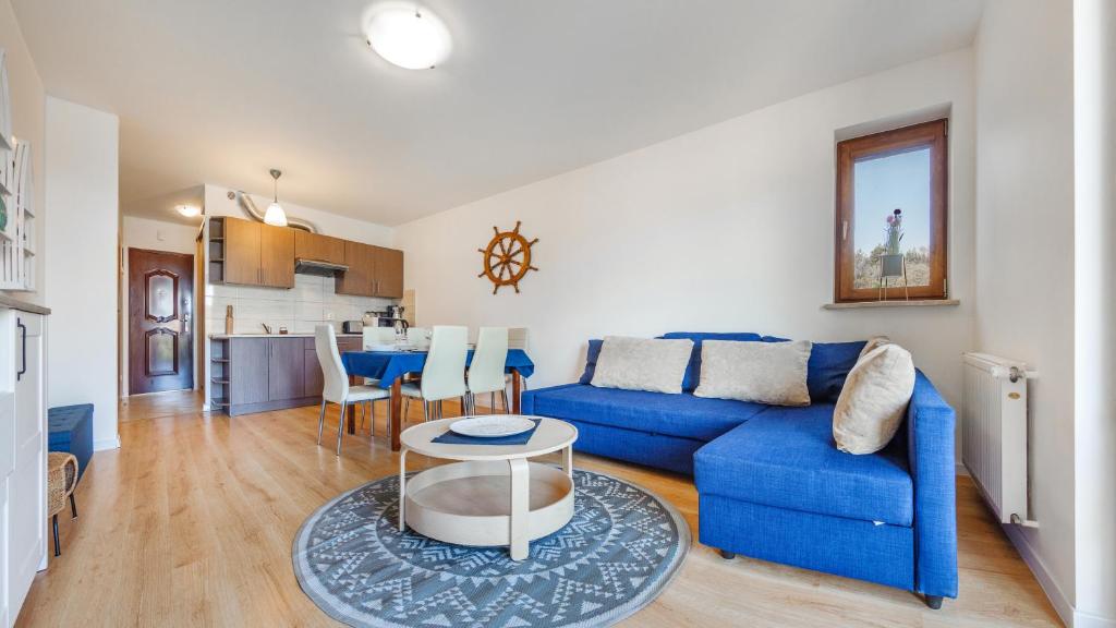 uma sala de estar com um sofá azul e uma mesa em Apartamenty Sun & Snow Gdańska II em Krynica Morska