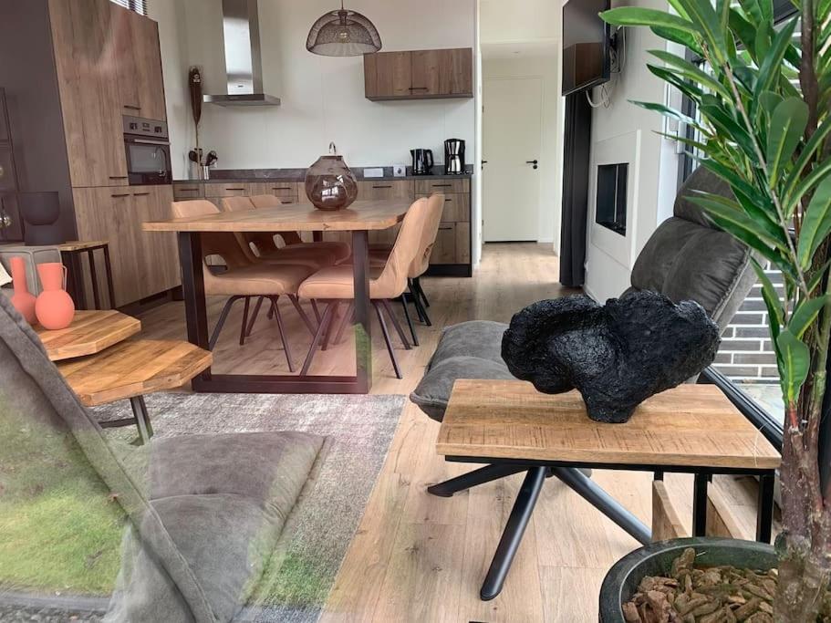 a living room with a table and a dining room at Ferienhaus Holland Cube NB 15 im EuroParcs Bad Hoophuizen - 6 Personen in Hulshorst
