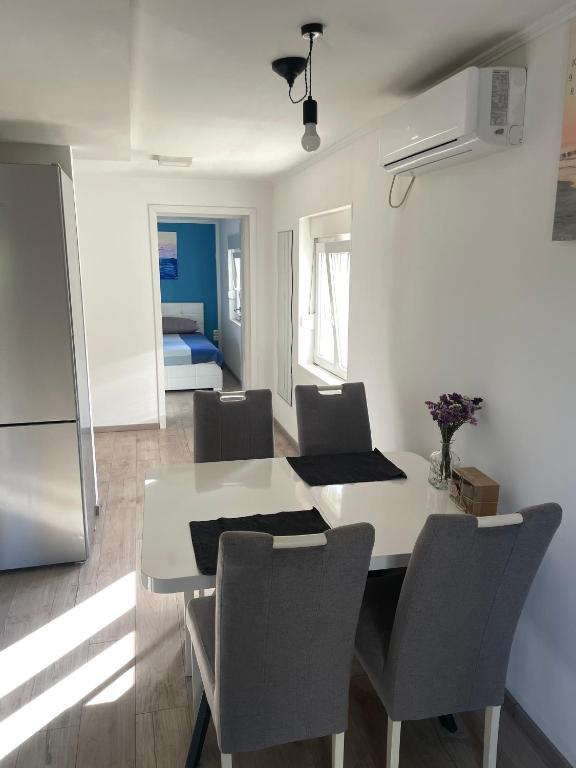 a kitchen and dining room with a white table and chairs at House Lovre in Zadar