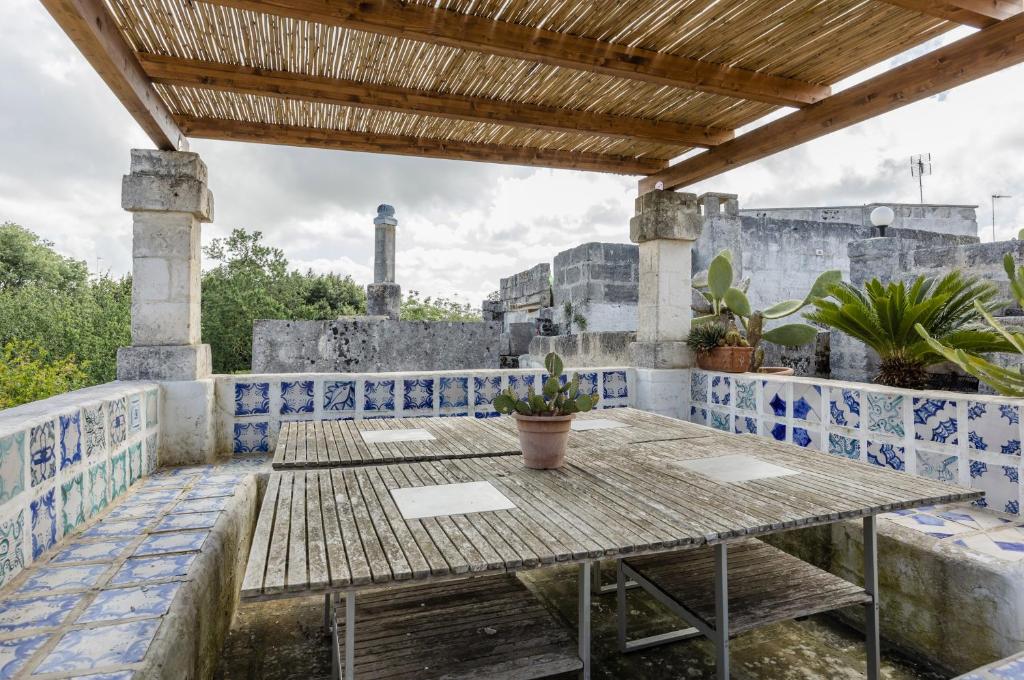 un tavolo su un balcone con piastrelle bianche e blu di Casa dei 5 Camini with terrace a Ortelle