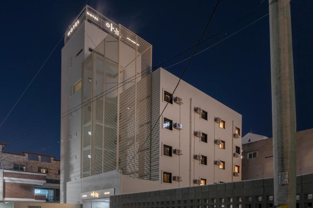 a tall white building with lights on it at night at The Hyoosik Aank Hotel Cheongju Uam 2nd Branch in Cheongju