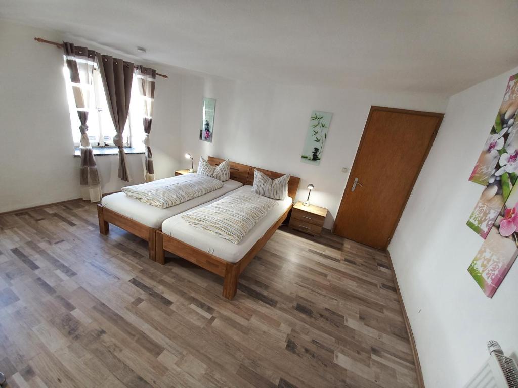 1 dormitorio con 1 cama y suelo de madera en Zentrum Füssen Ferienwohnung en Füssen