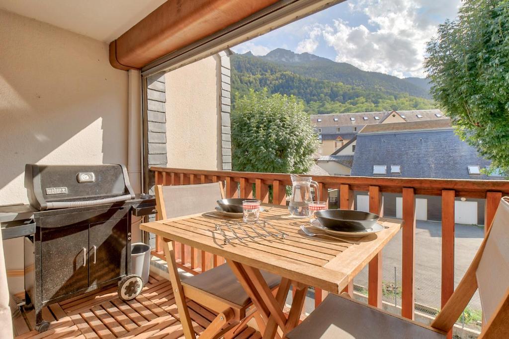 - un balcon avec une table en bois et un grill dans l'établissement Vue Montagne 4 étoiles, à Saint-Lary-Soulan