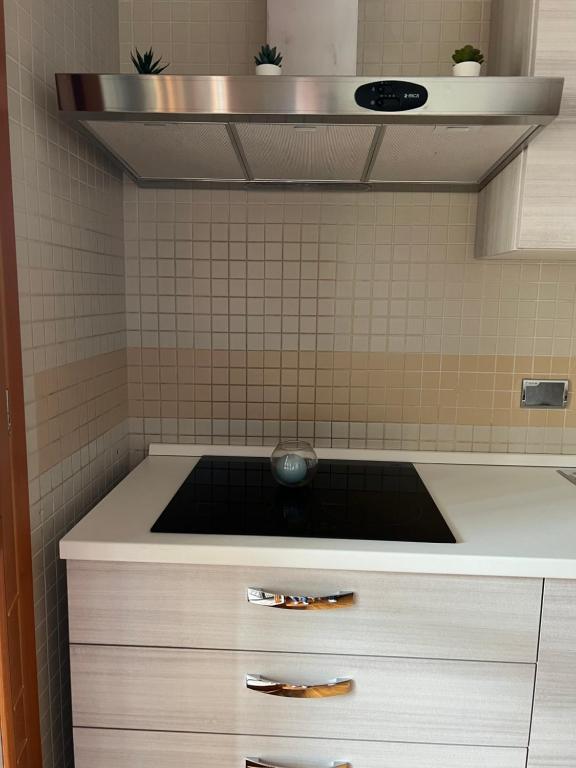 a kitchen with a sink and a tiled wall at Mary's house in Rome