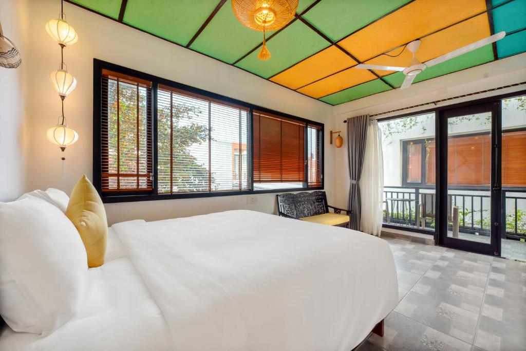 Postel nebo postele na pokoji v ubytování Sunkised Paddy Hoi An Villa