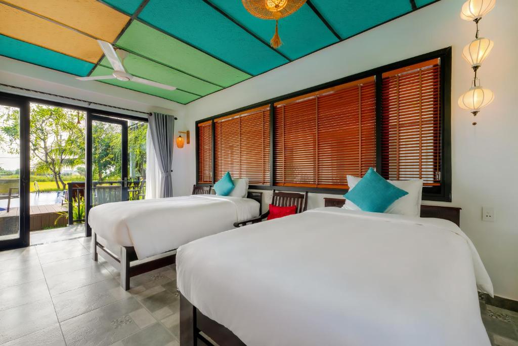 Postel nebo postele na pokoji v ubytování Sunkised Paddy Hoi An Villa