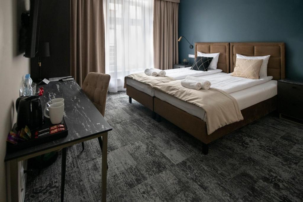 a bedroom with a large bed and a table at 4Wings Apartments in Krakow