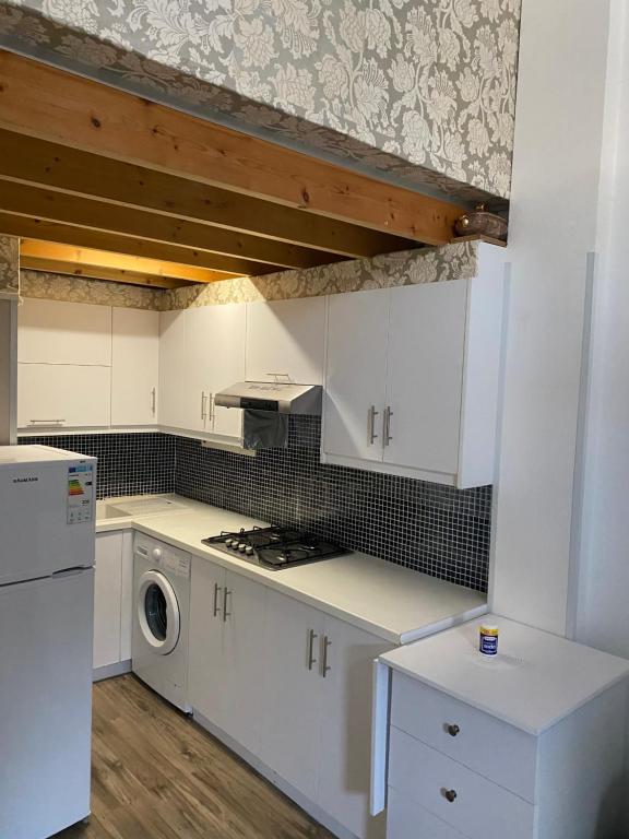 a kitchen with white cabinets and a washer and dryer at Cozy studio in town center 2 in Limassol