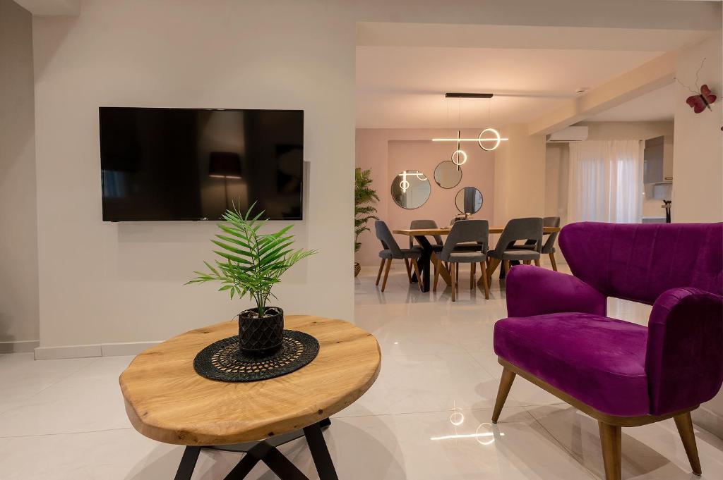 a living room with purple chairs and a table at CHE BELLO LUXURY APARTMENTS in Preveza