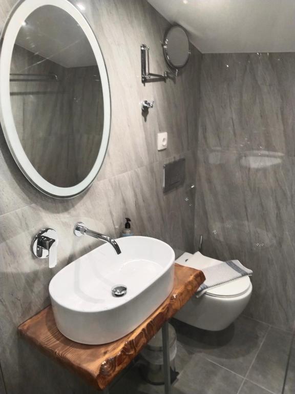 a bathroom with a sink and a toilet and a mirror at Hotel Almira in Agia Triada