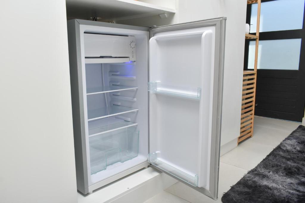 an empty refrigerator with its door open in a kitchen at Falcons Rest in Pretoria