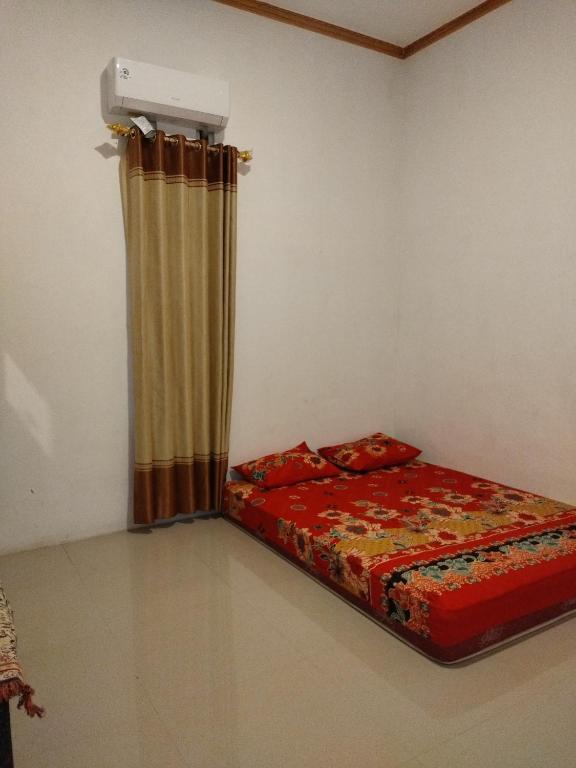 een slaapkamer met een bed met een gordijn en een kachel bij Pakok homestay in Kuta Lombok