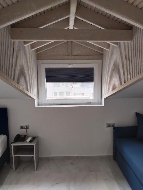 a living room with a window and a couch at Hotel Almira in Agia Triada